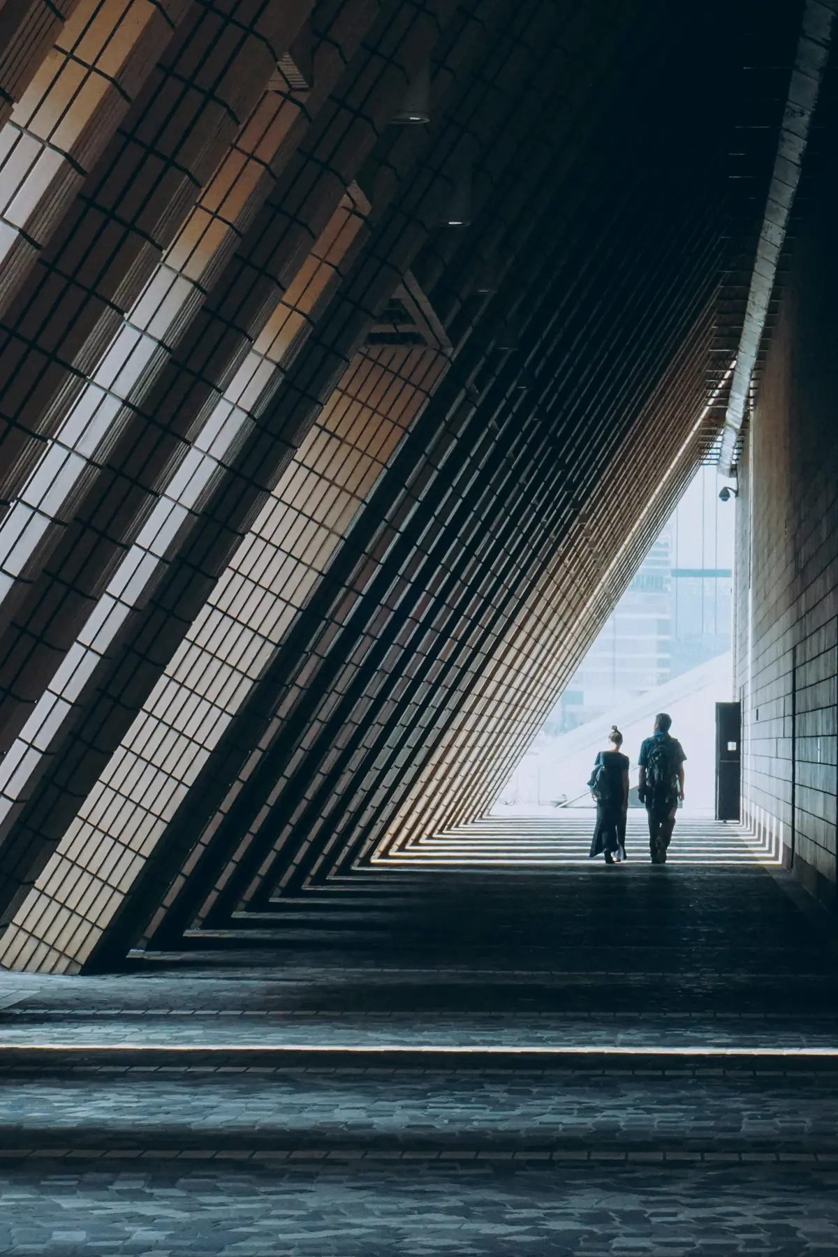 A pedestrian walking through contrasting light and shadow in Hong Kong